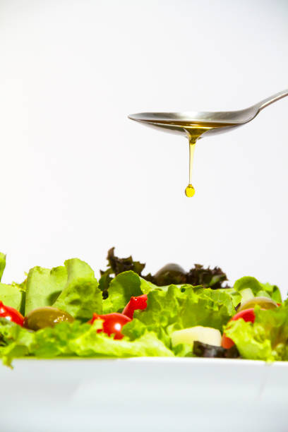 istock Olive oil splashing on a fresh salad isolated 1224501021