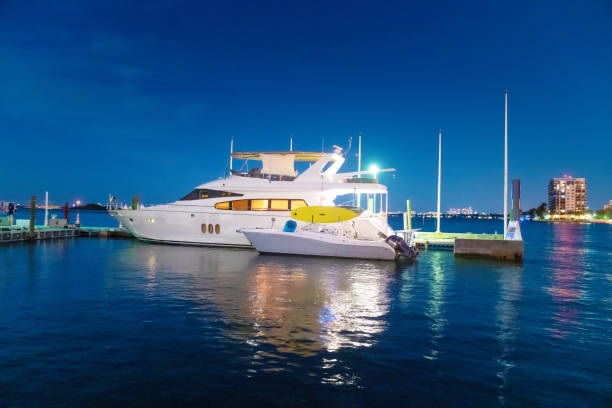 Illuminated yachts and towering masts reflect off the calm waters of Palma Marina, with a glowing cruise ship in the distance, capturing Mallorca's serene yet vibrant nightlife by the harbor.