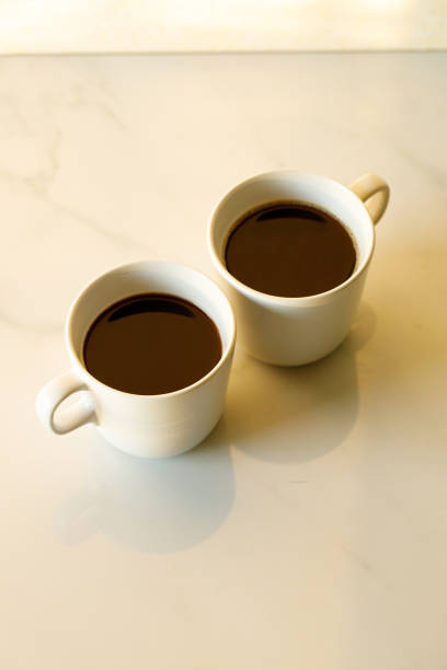 istock cups of coffees on white marble table in morning light 1224506593
