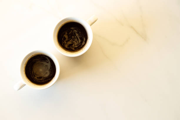 istock cups of coffees on white marble table in morning light 1224506601