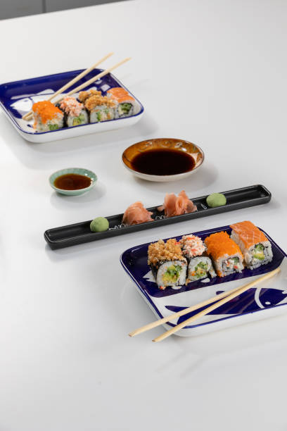 set von sushi und brötchen mit lachs und thunfisch, avocado, california, maki, sojasauce, essstäbchen aus nächster nähe. - maki sushi japanese culture food and drink still life stock-fotos und bilder