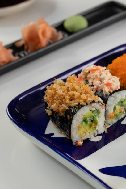 set de sushi y rollos con salmón y atún, aguacate, california, maki, salsa de soja, palillos de primer plano. - maki sushi japanese culture food and drink still life fotografías e imágenes de stock