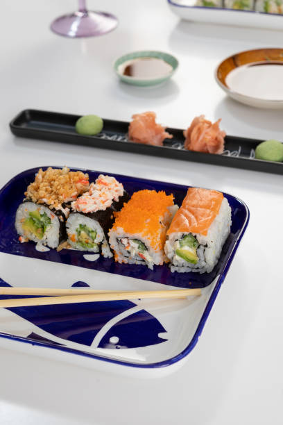 set von sushi und brötchen mit lachs und thunfisch, avocado, california, maki, sojasauce, essstäbchen aus nächster nähe. - maki sushi japanese culture food and drink still life stock-fotos und bilder