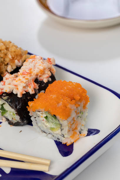 set de sushi y rollos con salmón y atún, aguacate, california, maki, salsa de soja, palillos de primer plano. - maki sushi japanese culture food and drink still life fotografías e imágenes de stock