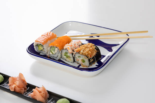 set von sushi und brötchen mit lachs und thunfisch, avocado, california, maki, sojasauce, essstäbchen aus nächster nähe. - maki sushi japanese culture food and drink still life stock-fotos und bilder