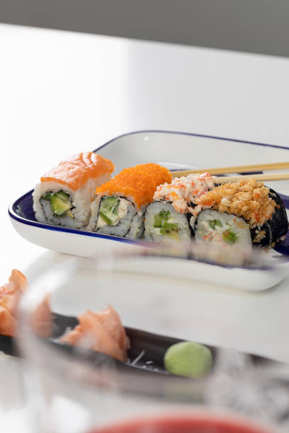 set de sushi y rollos con salmón y atún, aguacate, california, maki, salsa de soja, palillos de primer plano. - maki sushi japanese culture food and drink still life fotografías e imágenes de stock