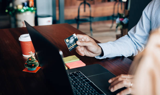 istock Online shopping concept with man hand using laptop and looking credit card for purchase order product. 1224508036