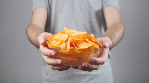 istock Caucasian man with tasty potato chips. 1224511743