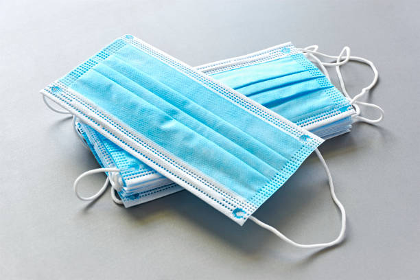 Blue antiviral medical face masks on grey