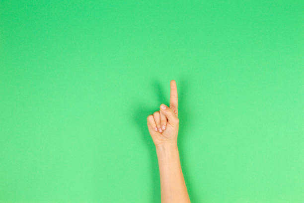 istock Kid hand showing one finger on green background 1224513962