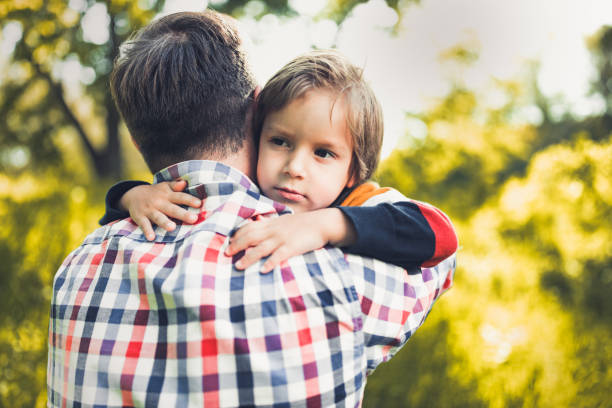 istock Sad little boy being consoled by his single father in nature. 1224514859