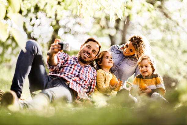 istock Happy family taking a selfie with digital camera in nature. 1224515331
