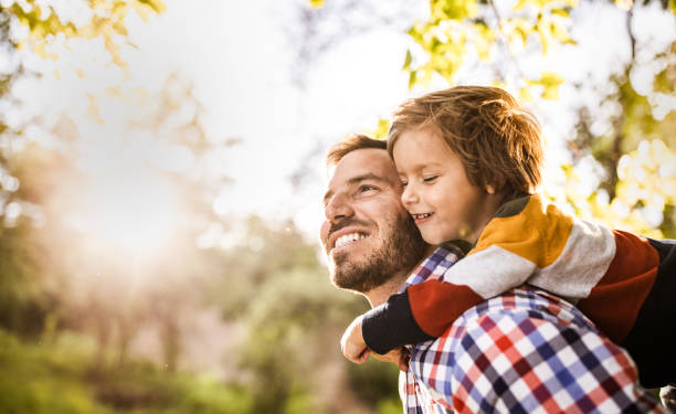 istock Happy single father piggybacking his small son in the park. 1224516599
