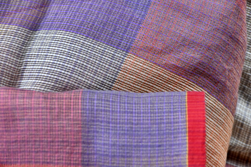 A close-up full frame of purple toned chequered material.