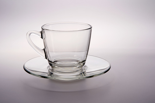 glass cup and saucer on white background