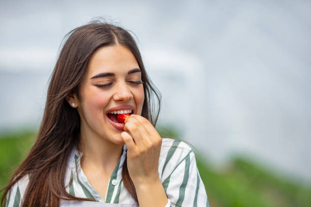 istock Pretty young female eating fresh strawberry. 1224521712
