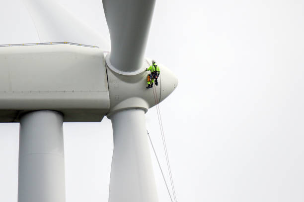 i tecnici dell'accesso alle funi si sono calati in corda doppia per lavorare sulla lama della turbina eolica e preparare protezioni per le funi sulla corda. - working windmill foto e immagini stock