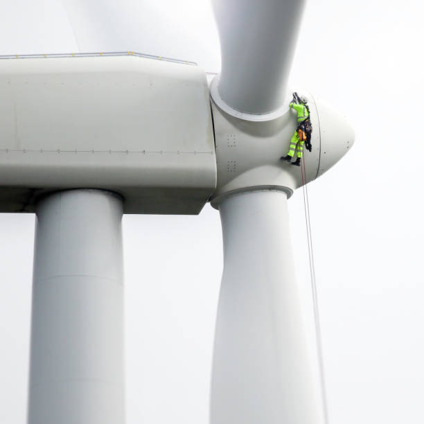 istock Professional rope access technicians rappelling down to working on blade of wind turbine and preparing rope protectors on the rope. 1224521965