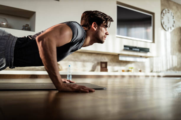 muscular build man exercising push-ups at home. - exercising men push ups muscular build imagens e fotografias de stock