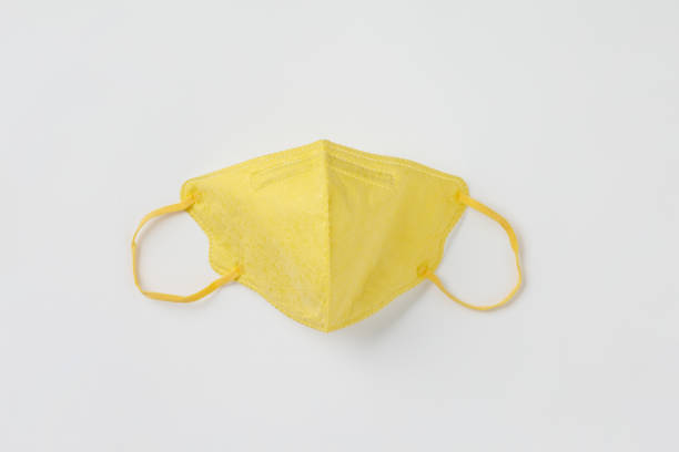 istock Yellow medical mask on white paper background flat lay 1224522963