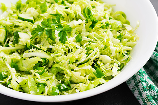 Vegetarian salad. Spring vegan salad with cabbage, cucumber, green onion and parsley.
