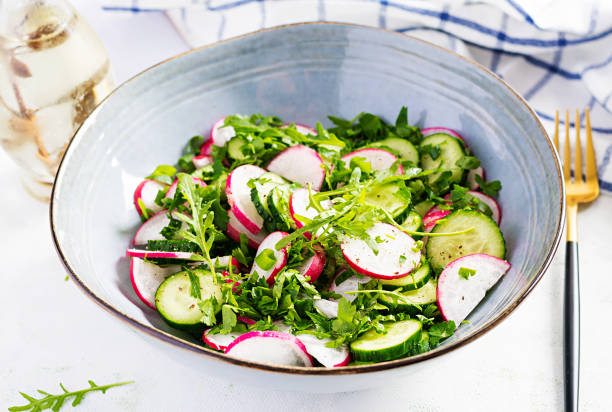 Vegetarian vegetable salad of radish, cucumbers, arugula and green onions. Healthy  vegan food. Vegetarian vegetable salad of radish, cucumbers, arugula and green onions. Healthy  vegan food. radish stock pictures, royalty-free photos & images