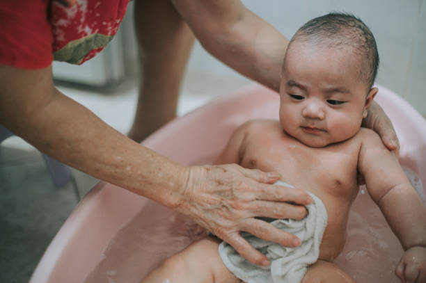 아시아 중국 할머니 청소 하 고 수건을 사용 하 여 욕조에서 그녀의 손자에 대 한 목욕을 복용 - baby wipe rubbing cleaning human hand 뉴스 사진 이미지