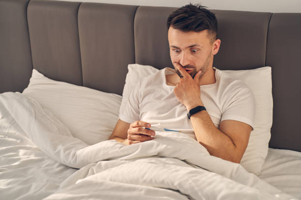 istock Man staying in bed and looking surprised 1224527145