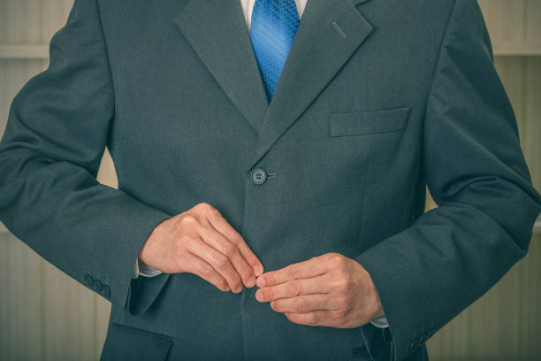 les mains mâles attachent un bouton sur le costume. - lapel suit jacket necktie photos et images de collection