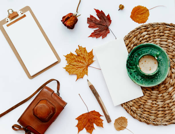 istock Trendy flat lay composition with coffee cup, old retro camera and autumn leaf, Office table with clip board, blogger concept 1224528717