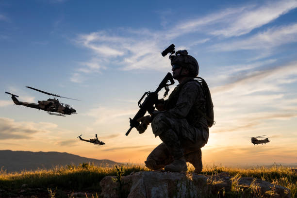 Military mission concept Military Helicopters flying behind kneeling soldier at sunset us military silhouette stock pictures, royalty-free photos & images