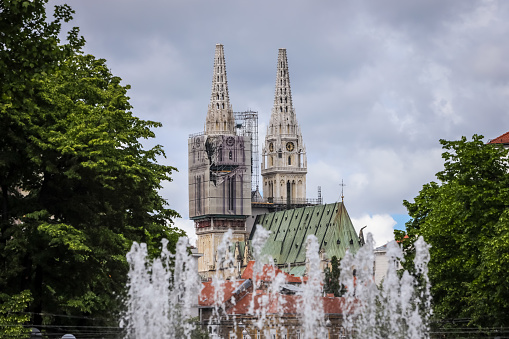 Zagreb, Croatia - 15 April, 2020 : Zagreb cathedral without both crosses on the top of the towers after earthquake that have damage it and water fountain in foreground in Zagreb, Croatia.