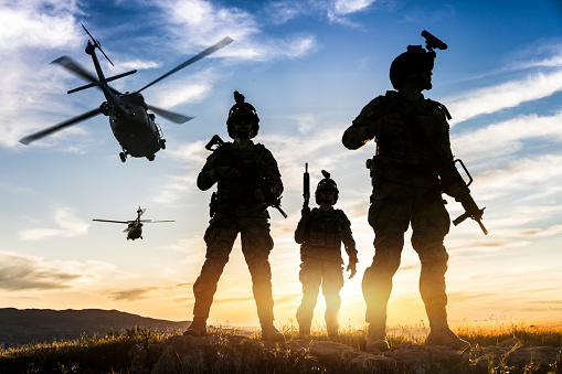 Silhouettes of soldiers during Military Mission at sunset