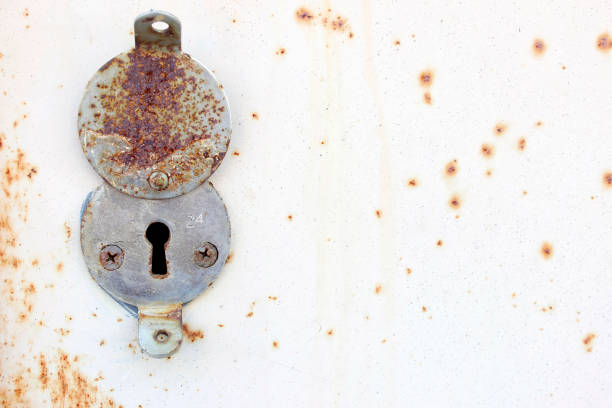 Access denied concept. Old rusty lock of a simple safe on a beige metal background.