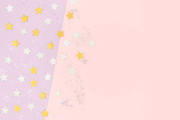 istock Silver and gloden stars confetti scattered on a pink pastel background. 1224536848