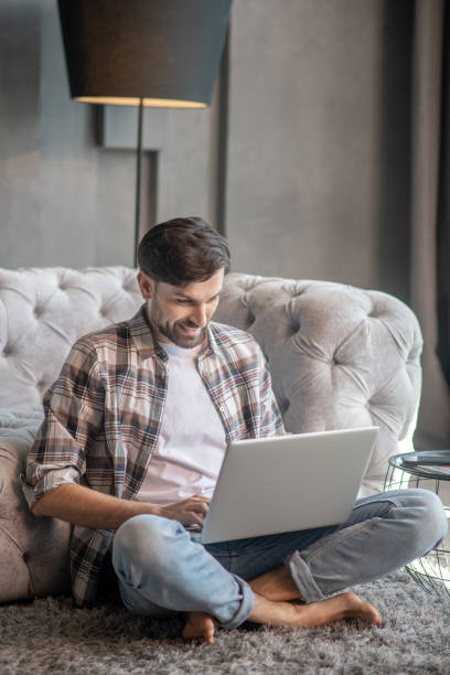 istock Man with a laptop sitting on the floor. 1224537447