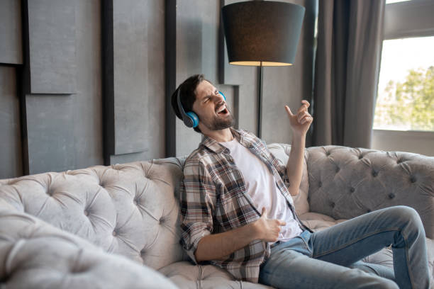 istock Joyful young man in headphones singing enthusiastically. 1224537467