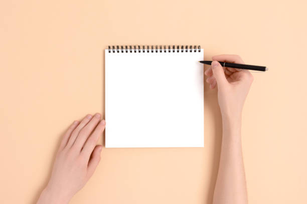 istock Female hands hold pen and notepad. Blank copybook mockup. 1224538195