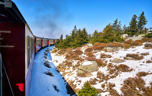Steam train on the Brocken mountain with snow in winter. Dynamics through motion blur.