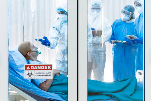 istock Infested coronavirus covid 19 patient wearing air ventilator is temperature tested by coronavirus covid 19 disease doctor with a team monitoring the symptom in clean quarantine room with danger outbreak alert sign 1224538737