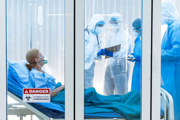 istock Infested coronavirus covid 19 patient in clean quarantine room with danger outbreak alert sign with team of coronavirus covid 19 experts discussion 1224538751
