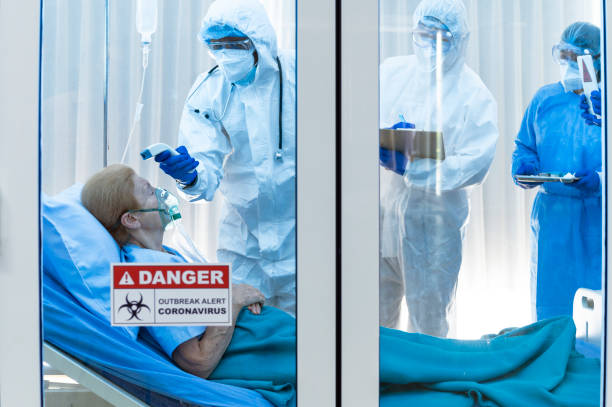 istock Infested coronavirus covid 19 patient wearing air ventilator is temperature tested by coronavirus covid 19 disease doctor with a team monitoring the symptom in clean quarantine room with danger outbreak alert sign 1224538770