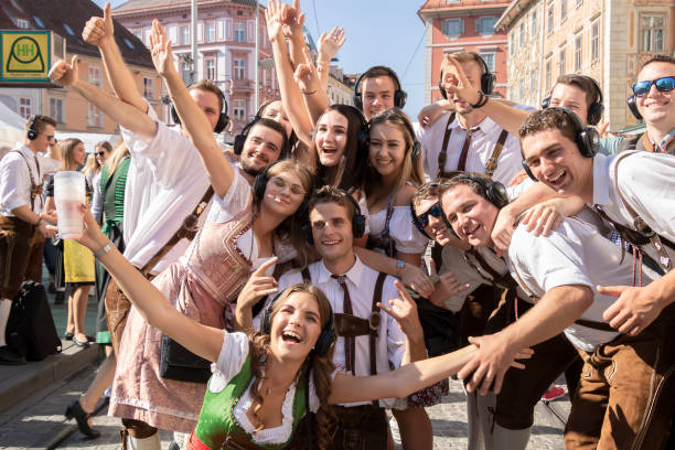 group of cheerful beautiful young people in bright national costumes posing for photo. - dirndl traditional clothing austria traditional culture imagens e fotografias de stock