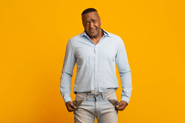 istock Sad mature african american man showing empty pockets 1224540842