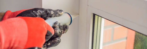 istock Man in a blue shirt does window installation BANNER, LONG FORMAT 1224541170