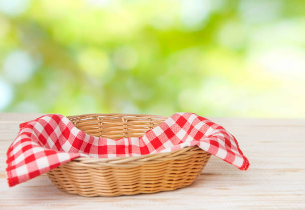 istock Wicker basket with red cotton napkin inside on a wooden table 1224541202