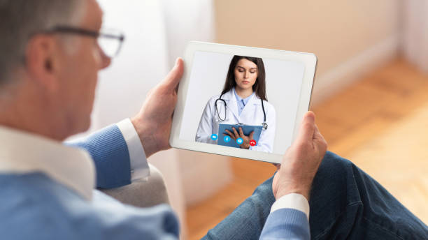 istock Man having video chat with doctor on tablet at home 1224541324