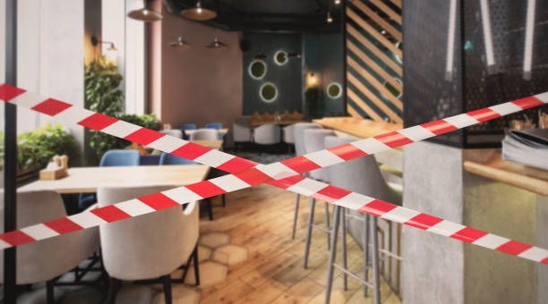 Hazard safety stripes across empty closed restaurant Quarantine Zone Warning Tape, Do Not Cross Concept. Red and white hazard safety stripes across empty closed restaurant barricade photos stock pictures, royalty-free photos & images