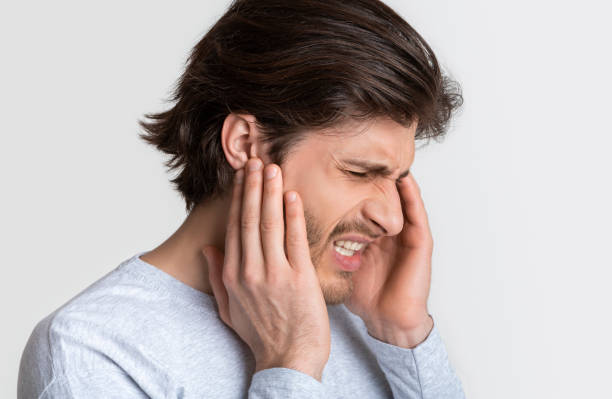 istock Man with earache is holding sore spot 1224542241