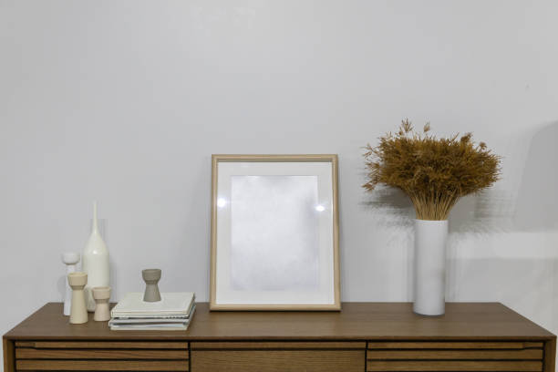 istock Empty mockup wooden frame and dry flower pot on cabinet with white wall 1224542610